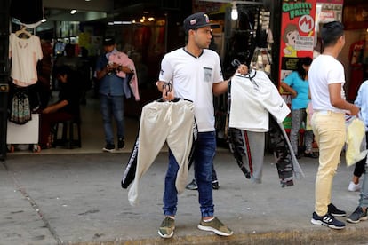 Un inmigrante venezolano vende ropa en Lima.