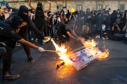 Manifestantes queman un escudo de la policía frente a Palacio Nacional.