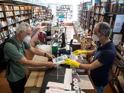 Un librero entrega un pedido a su cliente en Málaga tras el paso a la fase 1 de esa ciudad.
