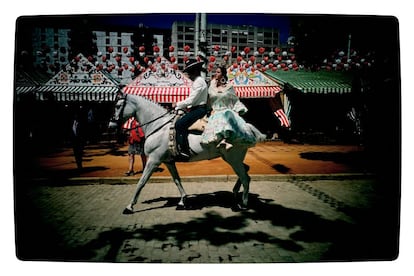 La noche del 'pescaíto' y el tradicional alumbrado es el pistoletazo de salida que anuncia un año más el inicio de la Feria de Abril de Sevilla. En la imagen, una pareja monta a caballo por el paseo, durante el martes de feria en Sevilla