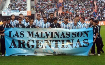 Los jugadores argentinos muestran una pancarta antes de jugar con Eslovenia. 