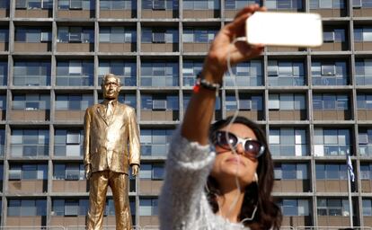 Una mujer se toma un selfi con la estatua del primer ministro israelí, Benjamin Netanyahu, creada por el artista Itay Zalait como una protesta política, y que fue colocada a las puertas del Ayuntamiento de Tel Aviv (Israel) sin un permiso oficial, el 6 de diciembre de 2016.