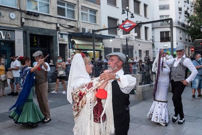 Baile de chulapos en la salida de la boca de metro de Lavapiés, en Madrid, durante las fiestas del barrio.
