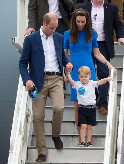 Los duques de Cambridge y su hijo bajando de un avión.