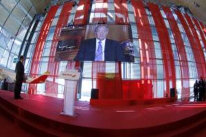 Acto de presentación de la nueva imagen de Iberia, esta mañana en la T4 del aeropuerto de Barajas, que ha corrido a cargo de Antonio Vázquez (i), en su último acto como presidente de la aerolínea, y en el que el A330 ha sido bautizado como "Juan Carlos I". En la imagen, el vídeo en el que el Rey -que ahora se encuentra ingresado en la clínica Quirón- agradecía este acto.