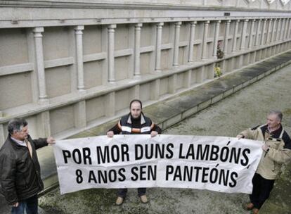 Tres hombres muestran la pancarta con la que salieron a manifestarse los vecinos en varias ocasiones contra la Iglesia y la constructora.