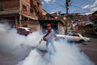 Un trabajador participa en una jornada de fumigación contra mosquitos en un barrio de Caracas.