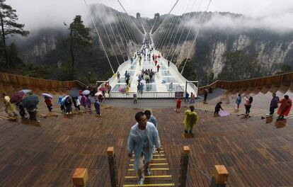 Vista del puente de Zhangjiajie, en el parque natural del mismo nombre, en la provincia de Hunan, China. Se trata del puente de cristal más alto y largo del mundo, de 430 metros de longitud y 300 de altura. Diseñado por el arquitecto israelí Haim Dotan e inaugurado hace dos meses, el puente tiene seis metros de ancho, une dos acantilados de la montaña Tianmen a través de 99 paneles con tres capas de cristal y está preparado para que sobre él circulen hasta 800 personas a la vez.