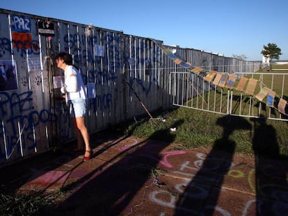 Uma mulher olha a través do muro instalado em Brasília.
