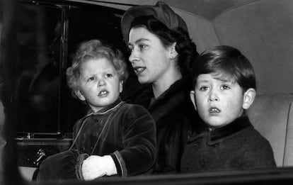 1953. La Reina Isabel II de Inglaterra (c) con sus hijos, la princesa Ana (i) y el Príncipe Carlos (d), en un coche a su llegada a Londres, de unas vacaciones de navidad.