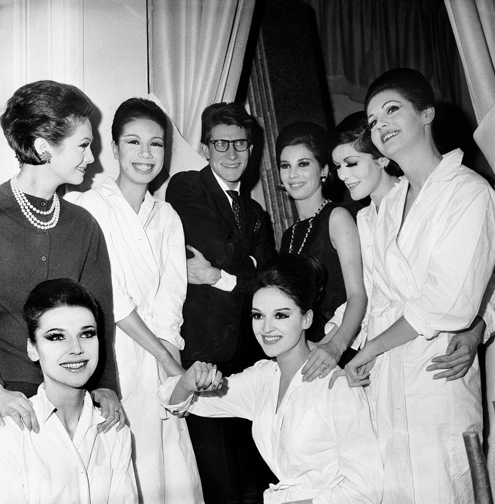 Yves Saint Laurent rodeado de las modelos que presentaron su primera colección. Junto a él, con albornoz, Fidelia.