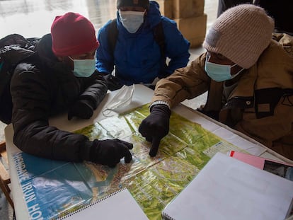 La red de acogida de Irún explica a tres migrantes el trayecto y horarios hasta la localidad francesa de Bayona, vía Hendaya.