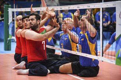 Sadegh Bigdeli (Iran), Petro Ostrynskyi y Sergii Shevchenko (Ucrania) compiten en en voley sentado.