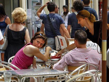 Clientes en la terraza de una cafetería en la ciudad de Valencia.