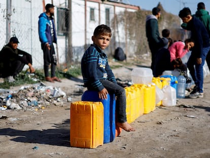 Un niño palestino desplazado se sienta en un bote de agua en un campamento de Rafah, en el sur de la franja de Gaza, el 18 de enero de 2024.