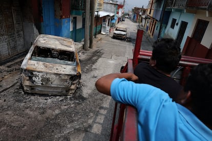 Habitantes de Tila (Estado de Chiapas) huyen de su comunidad entre vehículos calcinados durante enfrentamientos de grupos armados, el 10 de junio.