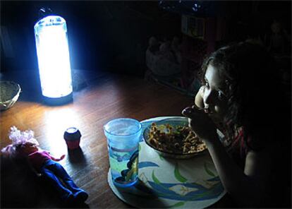 Una niña come bajo la luz de una linterna en La Habana durante el apagón del pasado viernes.

.