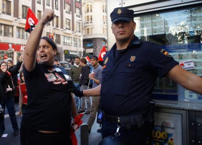 Un agente de Policía para a un miembro de un piquete en la Gran Vía de Madrid.