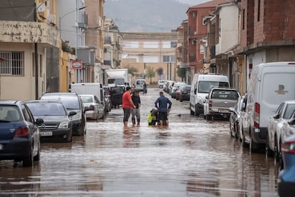 Varias personas observan los daños causados por la dana, este martes en Llombay, Valencia.