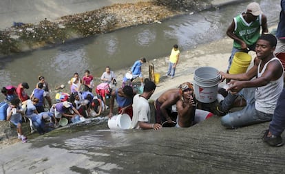 Venezuelanos coletam água no Rio Guaire, em Caracas.