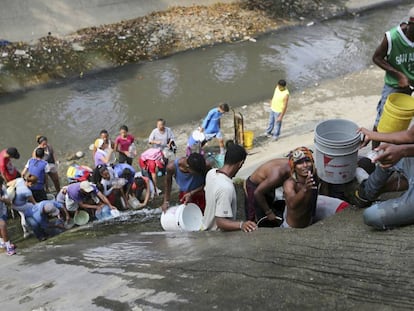 Venezuelanos coletam água no Rio Guaire, em Caracas.