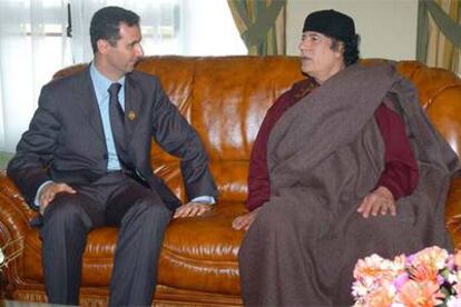 El presidente sirio, Bachar el Asad, charla con el líder libio, Muammar el Gaddafi, durante la cumbre árabe.