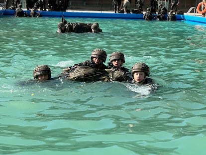 La dama cadete Borbón Ortiz, junto a unos compañeros, simula en una piscina el paso de un curso de agua con el equipo de combate.