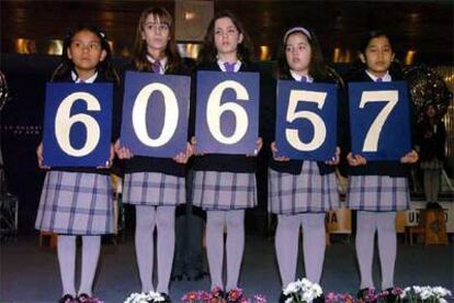 Las niñas del colegio de San Ildefonso muestran el primer premio del sorteo de <i>El Niño</i>.