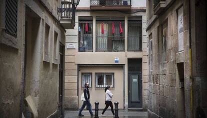 Draps vermells en protesta pels narcopisos al carrer d'en Roig del Raval.