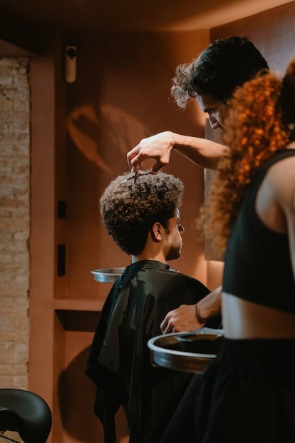 Un especialista de Curly Lab tratando el cabello afro de un cliente.