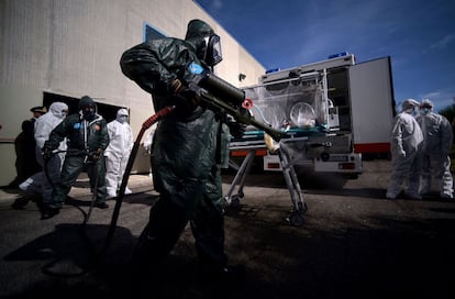 Personal aeronáutico italianos vestidos con trajes protectores en un simulacro de transpote de una víctima de ébola.