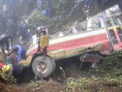 Bomberos y voluntarios retiran los cad&aacute;veres entre los restos un veh&iacute;culo siniestrado en Guatemala