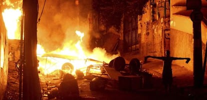 A man gestures in front of a fiery barricade set up by protestors near Rio's famed Copacabana beach district.