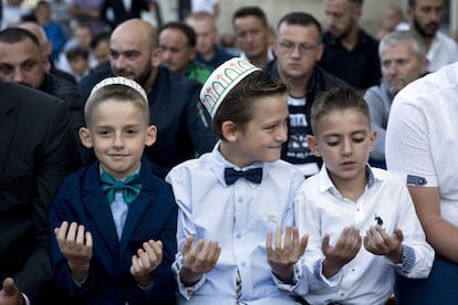 Tres niños participan en los rezos de Eid al-Adha en la mezquita Sultan Mehmet Fatih de Pristina, Kosovo, el 21 de agosto de 2018. 