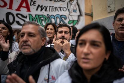 Uno de los profesionales concentrados frente al centro de salud Palma Norte, en el barrio de Malasaña, silva en apoyo a la huelga de médicos de familia y pediatras. 

