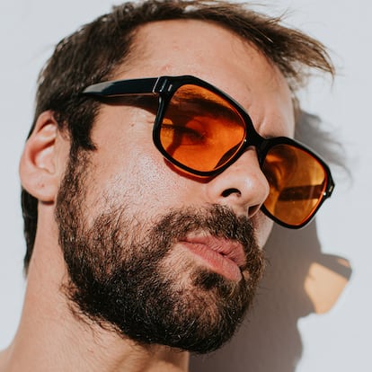 Un hombre con gafas con cristales naranjas.