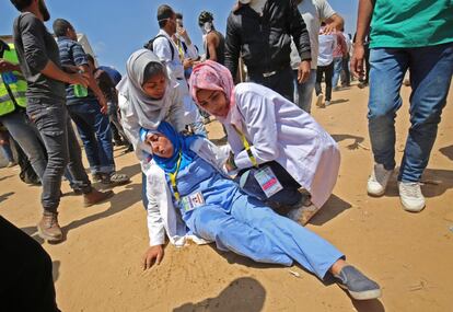 Una mujer médico atiende a una compañera herida durante los enfrentamientos con el ejército israelí al este de Khan Yunis, en la Franja de Gaza. 