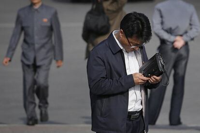 Pyongyang apuesta por un sistema donde la élite de confianza puede navegar por Internet con relativa libertad mientras que las masas se mantienen dentro de una intranet nacional minuciosamente vigilada y construida en parte con software robado. En la foto, varias personas utilizan ordenadores en el Complejo Sci-Tech de Pyongyang, el 16 de junio de 2017. En la foto, un hombre usa su teléfono inteligente en Pyongyang, el 5 de mayo de 2015.