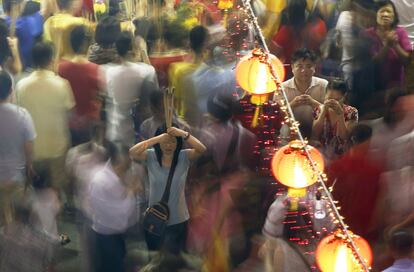 Devotees offer joss sticks ahead of the Lunar New Year at Kwan Im Thong Hood temple in Singapore February 18, 2015. Each year, at the stroke of midnight, hundreds of people vie to be the first to place joss sticks in an urn at the temple to mark an auspicious start to their year. The Chinese Lunar New Year on February 19 will welcome the Year of the Sheep (also known as the Year of the Goat or Ram). REUTERS/Edgar Su (SINGAPORE - Tags: SOCIETY ANNIVERSARY)