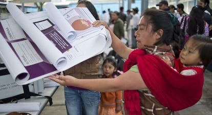 Una vocal de mesa coloca informaci&oacute;n electoral en un colegio en San Lorenzo Tlacoyucan, en la capital mexicana.