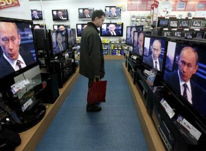 Un cliente sigue la intervención de Vladímir Putin desde una tienda en Moscú.