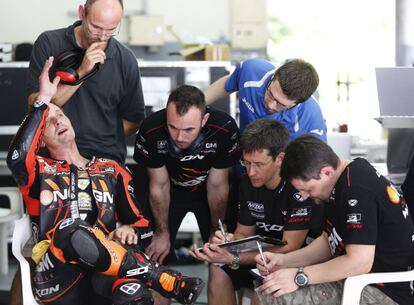 El piloto estadounidense Colin Edwards habla con sus mecánicos del equipo Kawasaki.