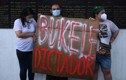Tres manifestantes sostienen una pancarta durante la protesta contra el desmantelamiento de la destitución del Constitucional y del fiscal general.