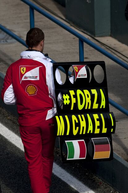 Un miembro del equipo Ferrari sostiene un cartel de apoyo a Michael Schummacher.