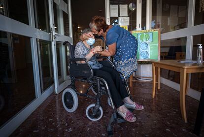 Dos familiares se abrazan con mascarilla en la residencia de mayores en La Cañada (Valencia), en septiembre.