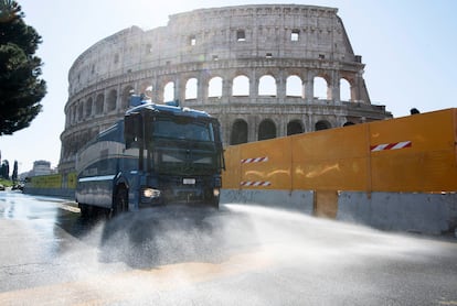 Un vehículo de la Policía italiana equipado con cañones de agua limpia las calles de Roma, junto al Coliseo, para luchar contra el coronavirus.