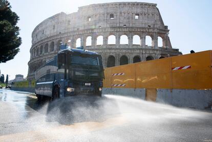 Un vehículo de la Policía italiana equipado con cañones de agua limpia las calles de Roma, junto al Coliseo, para luchar contra el coronavirus.