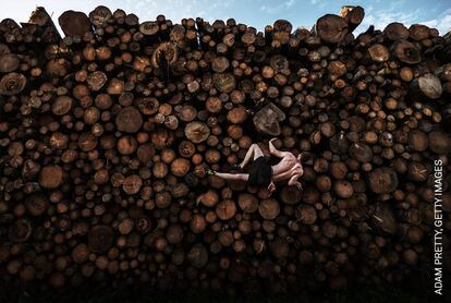 Georg sube a una pila de troncos mientras se entrena para practicar el 'bulder', en Kochel am See, Baviera, Alemania. Esta práctica consiste en escalar en pequeñas formaciones rocosas y cantos rodados de no más de seis metros de altura, sin cuerdas.