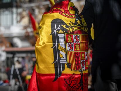 MADRID, SPAIN - 2023/11/19: A young man dressed in a pre-constitutional Spanish flag observes the annual event against the Democratic Memory Law called by the "Spanish Catholic Movement", an ultra-Catholic and far-right organization at the Plaza de Oriente. They have also protested the amnesty law in favor of Catalan independence politicians by the elected president Pedro Sanchez. (Photo by David Canales/SOPA Images/LightRocket via Getty Images)