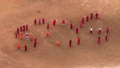 Detained migrants form the letters SOS with their bodies in the courtyard of the Bluebonnet detention center Tuesday in Anson, Texas.